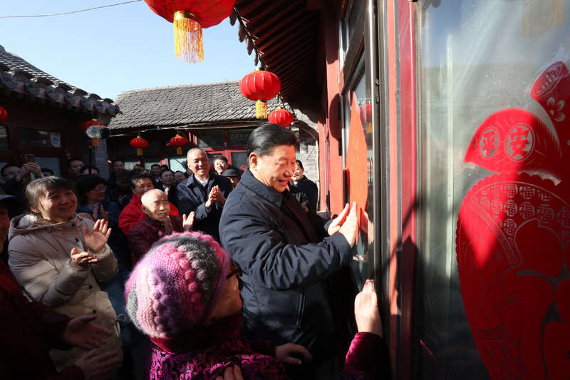 2019年2月1日上午，習近平在北京前門東區(qū)草廠四條胡同32號院，高興地拿起一幅“福”字，親自貼到門上，給這里的老街坊們拜年。新華社記者 鞠鵬 攝